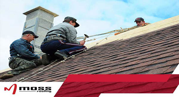 photo of workers on a residential roof repairing shingles